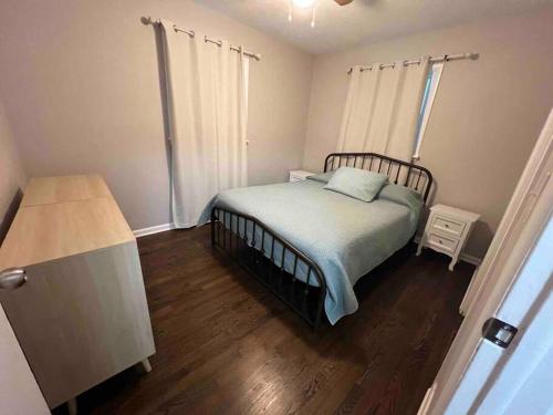 a bedroom with a bed and a wooden floor at Modern & Cozy 2 bedroom home near downtown Shawnee in Shawnee