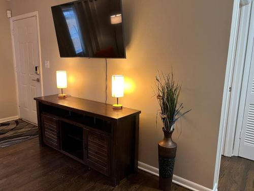 a room with two lamps and a television on a wall at Modern & Cozy 2 bedroom home near downtown Shawnee in Shawnee
