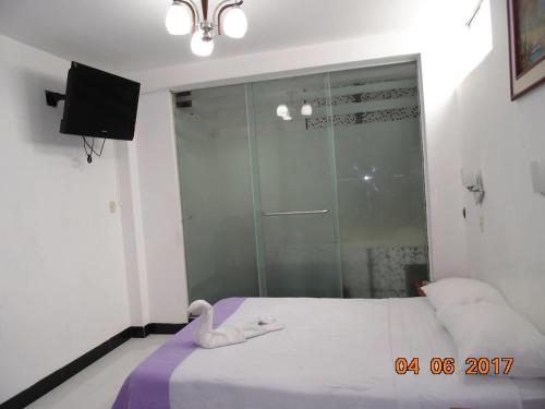 1 dormitorio con 1 cama y ducha acristalada en HOTEL BAYOVAR, en Piura
