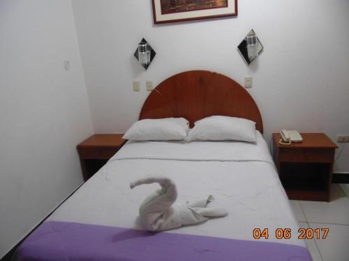 Un dormitorio con una cama con una serpiente. en HOTEL BAYOVAR, en Piura