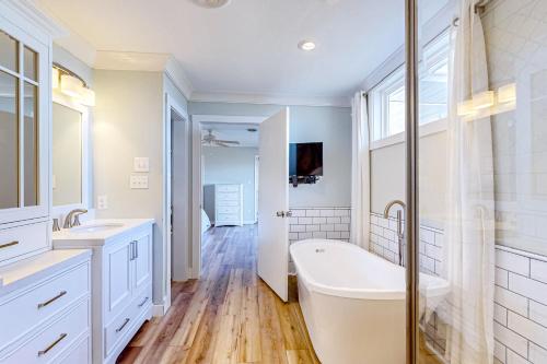 uma casa de banho com uma banheira, 2 lavatórios e um chuveiro em Living Water Estate em Atlantic Beach