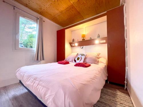 Schlafzimmer mit einem großen weißen Bett und einem Fenster in der Unterkunft Cosy Chalet au cœur du Sidobre avec Piscine et Spa in Vabre
