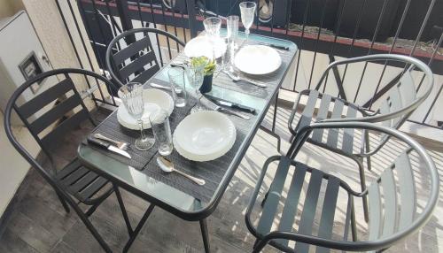 a table with chairs and plates and glasses on it at Dreams 1 in Kardítsa