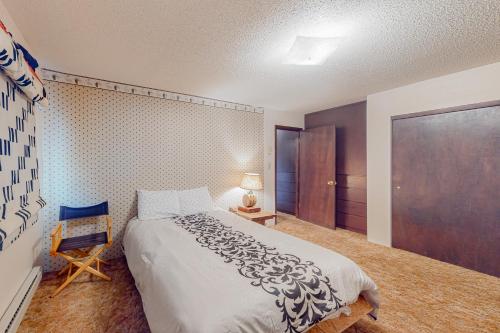 1 dormitorio con 1 cama grande y 1 silla en Western Wonders en Alamosa