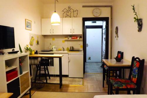 uma cozinha com armários brancos, uma mesa e uma porta em Studio5, sa parkingom, centar Obrenovca em Obrenovac