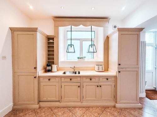 a kitchen with a sink and a window at Ty Crindau by Solace Stays (Pool Table) in Newport