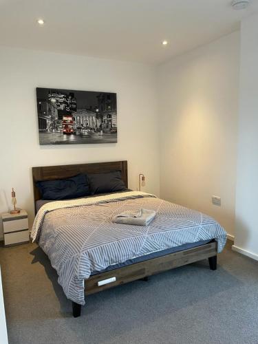 a bedroom with a bed with a picture on the wall at Luxury en-suite room Olympic Village in shared apartment in London