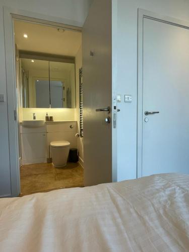 sypialnia z łóżkiem oraz łazienka z lustrem w obiekcie Luxury en-suite room Olympic Village in shared apartment w Londynie