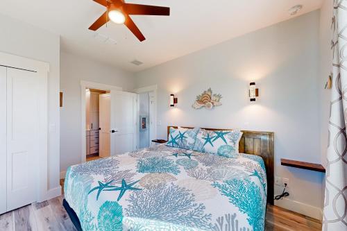 una camera da letto con un letto e un ventilatore a soffitto di Couple's Getaway, 2nd floor ocean view suite w/ beautiful sunrises, patio, AC a Flagler Beach