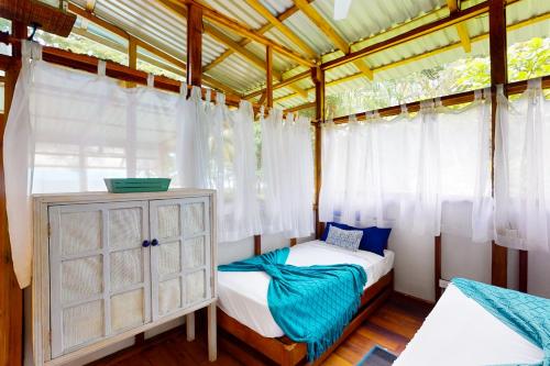 a bedroom with two beds and a dresser at Casa Beluga in Uvita