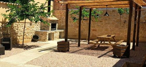 een patio met een picknicktafel en een stenen oven bij Apartamento Clau in Puigmoreno