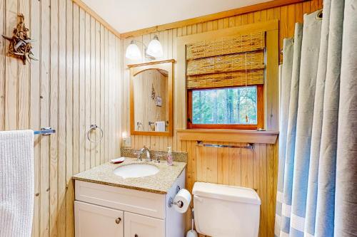 La salle de bains est pourvue d'un lavabo, de toilettes et d'une fenêtre. dans l'établissement Southside at Cobb Nob, à Southwest Harbor