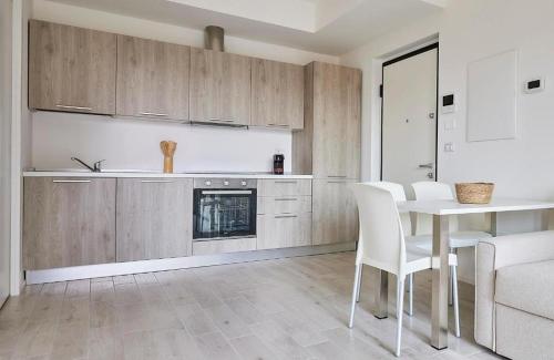 a kitchen with wooden cabinets and a table and chairs at New Twin Flat 1 - Vicino San Siro Stadium e New Palace in Milan