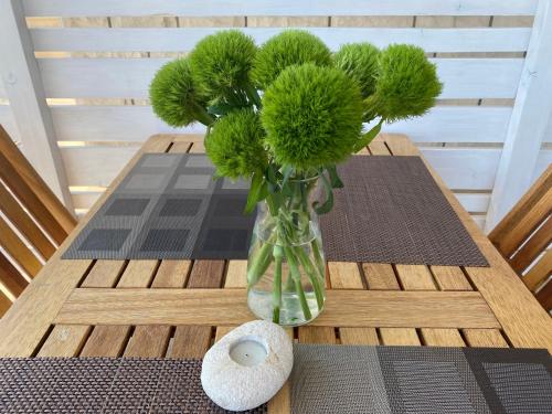 a vase filled with green flowers on a table at Apartments Zeljko in Lumbarda