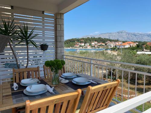 a table on a balcony with a view of the ocean at Apartments Zeljko in Lumbarda