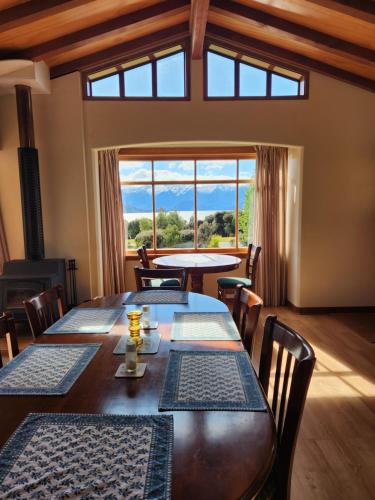 a dining room with a table and chairs and a large window at Manapouri Holiday Park in Manapouri