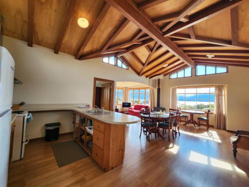 a kitchen and living room with wooden ceilings and a table at Manapouri Holiday Park in Manapouri