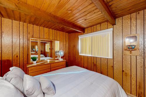 a bedroom with a white bed in a wooden wall at Cabin On The Lake in Harrison