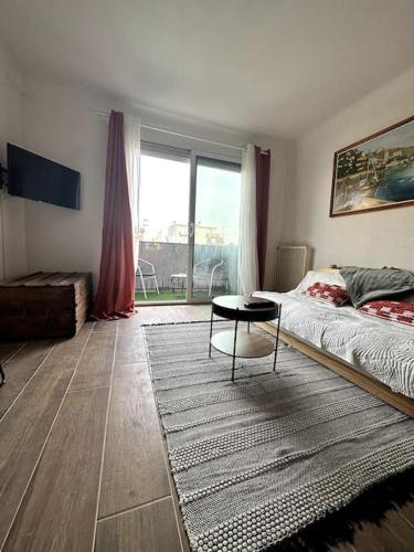 - un salon avec un lit et une table dans l'établissement Agréable T2 cosy - centre-ville, à Perpignan