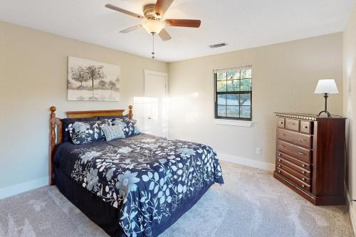 a bedroom with a bed and a ceiling fan at The Los Madrone Home in Pipe Creek