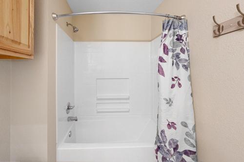 a bathroom with a shower with a shower curtain at The Los Madrone Home in Pipe Creek