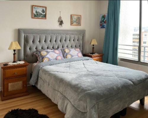 a bedroom with a large bed and two tables with lamps at Depto. Boulevard del Sol in Viña del Mar