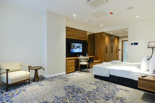 a hotel room with a bed and a chair and a desk at Hotel Vema in Visoko