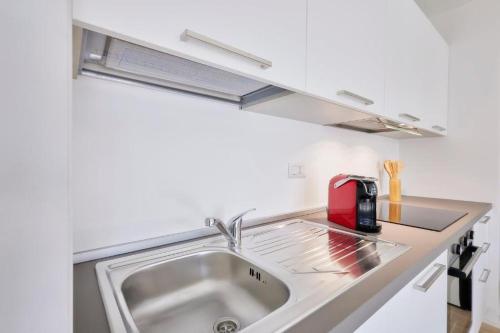 een keuken met een wastafel en een rode broodrooster bij New Twin Flat 2 - Vicino San Siro Stadium e M5 in Milaan