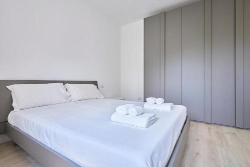 un letto bianco con due asciugamani sopra di New Twin Flat 2 - Vicino San Siro Stadium e M5 a Milano