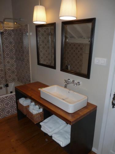 a bathroom with a sink and a mirror and towels at Quinta da Eira Velha in Aldeia do Mato