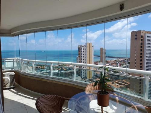 a balcony with a table and a view of the ocean at Studio Iracema 2001 in Fortaleza
