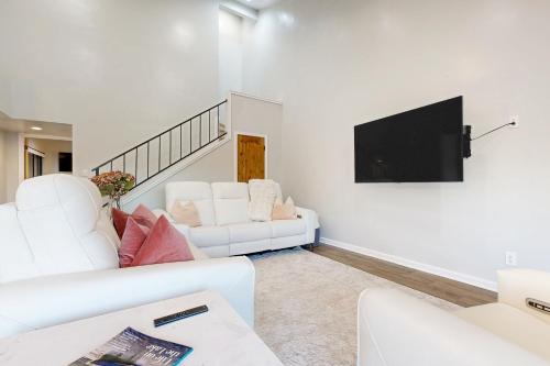 a living room with two white couches and a flat screen tv at Way to the Bay in Horseshoe Bay