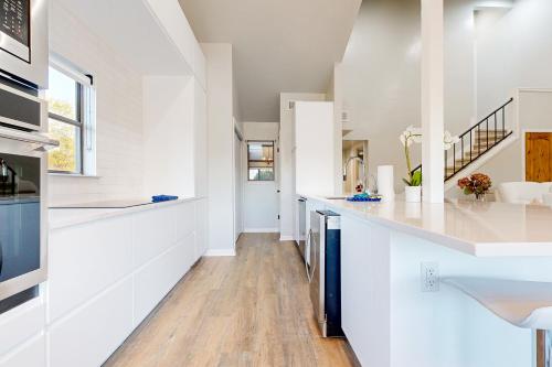 a kitchen with white walls and wooden floors at Way to the Bay in Horseshoe Bay