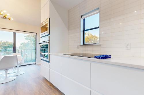 a kitchen with white cabinets and a window at Way to the Bay in Horseshoe Bay