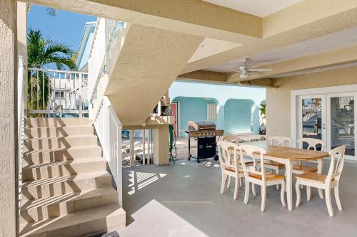 a patio with a table and chairs and a staircase at Fantastic Fifth Street in Key Colony Beach