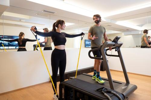 a man and a woman on a treadmill in a gym at Wellness Smart Suites in Bolzano