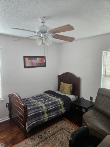 a living room with a ceiling fan and a couch at RestStop Hostel in Houston