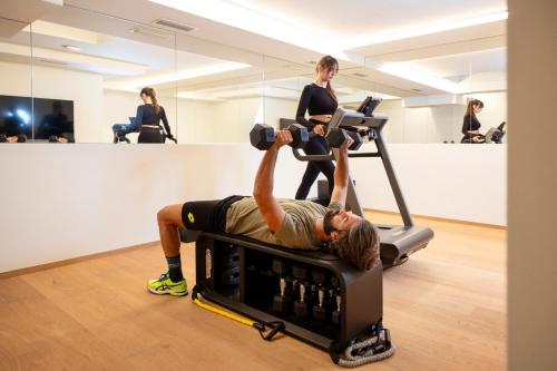 a man exercising on an exercise bike in a gym at Wellness Smart Suites in Bolzano