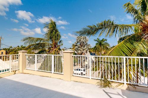 a white fence with palm trees in the background at Fantastic Fifth Street in Key Colony Beach