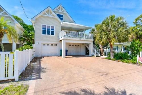 uma casa branca com uma cerca branca e uma entrada em Two For Sea House #54538 Home em Holmes Beach