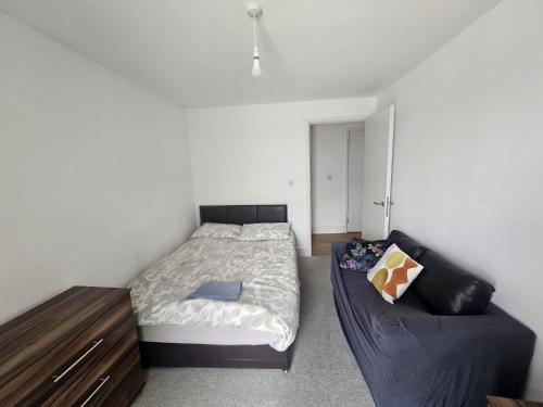 a bedroom with a bed and a couch at Hippersley Point, Tilston Bright Square, Abbey Wood, London SE2 9DR, UK in London