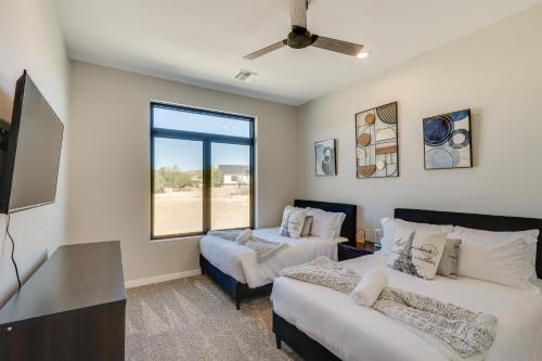 a bedroom with two beds and a flat screen tv at Luxurious Desert Oasis Fireplace and Private Pool! in Apache Junction