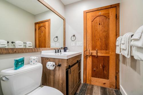 a bathroom with a toilet and a sink and a mirror at Pinehurst Paradise A in Thompsonville