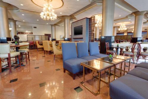 a lobby with a restaurant with blue chairs and tables at Drury Plaza St. Louis at the Arch in Saint Louis