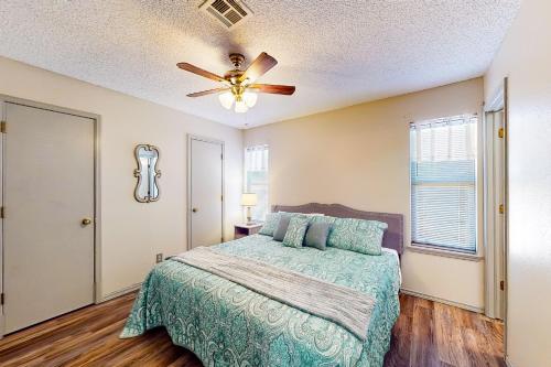 a bedroom with a bed and a ceiling fan at Casa de Cowboy in Stillwater