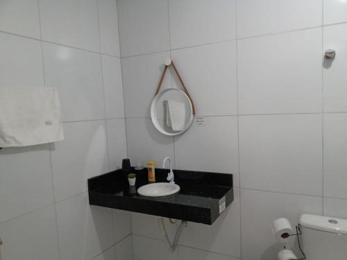 a bathroom with a sink and a mirror on a counter at Apê perto do Parque Euclides Dourado in Garanhuns