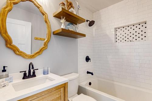 La salle de bains est pourvue d'un lavabo, de toilettes et d'un miroir. dans l'établissement Serene Cottage, à Charleston