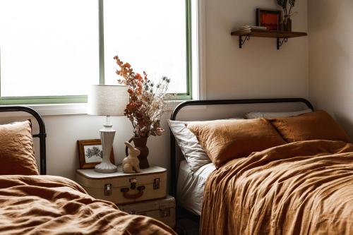 a bedroom with two beds and a window at Hey Little Joe - Cosy Retreat with Mountain Views in Warburton