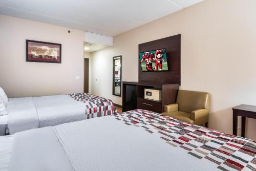a hotel room with two beds and a chair at Red Roof Inn Palatine in Palatine