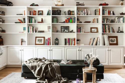a living room with white bookshelves and a couch at Hey Little Joe - Cosy Retreat with Mountain Views in Warburton